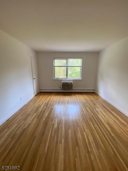 806 Morris Turnpike, Unit 2A8 Short Hills, NJ 07078 - Photo 9 of 13 an empty room with wooden floor and windows