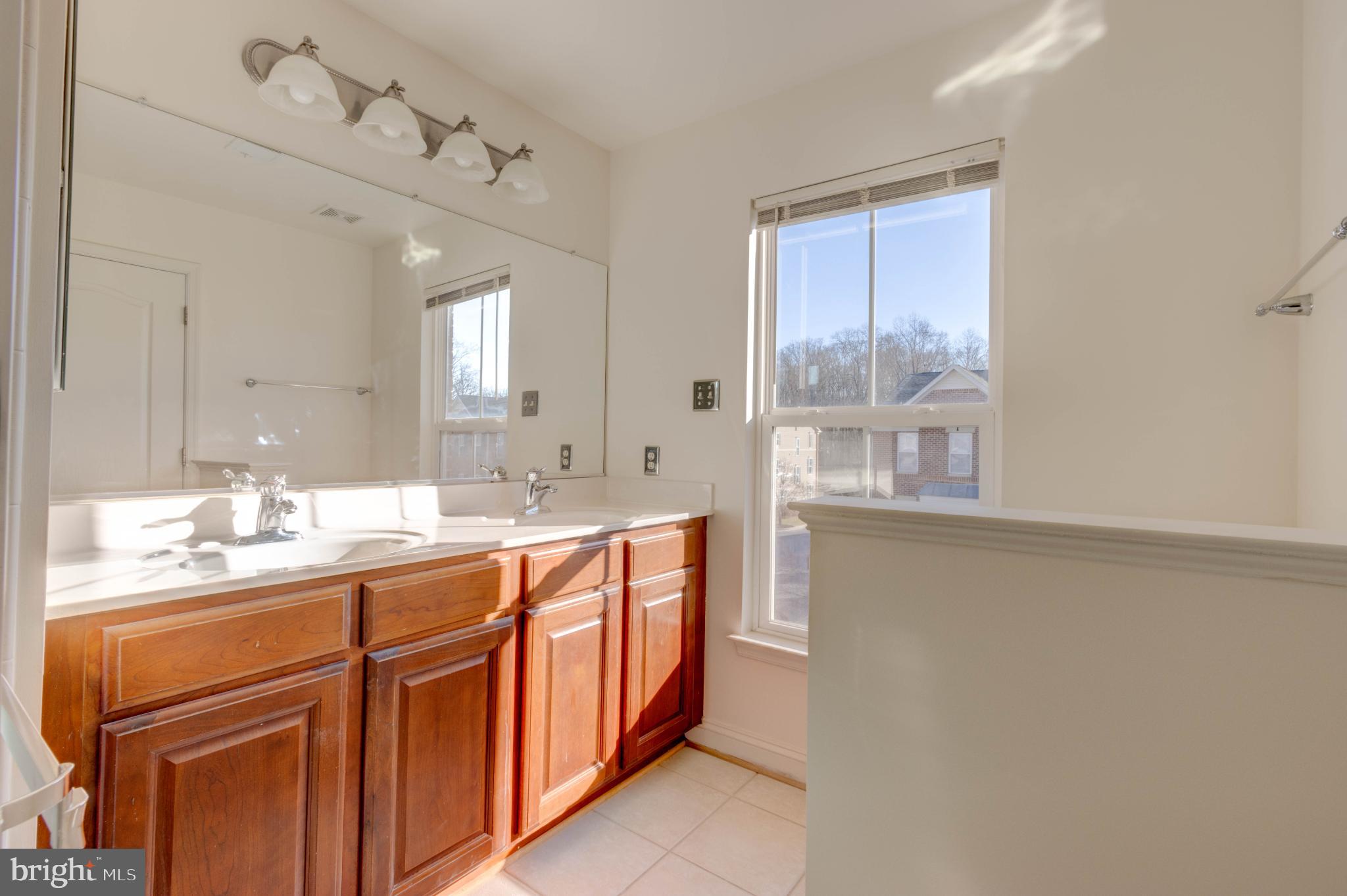 2629 Raptor Drive Odenton, MD 21113 - Photo 11 of 20 a spacious bathroom with a double vanity sink a mirror and a bathtub