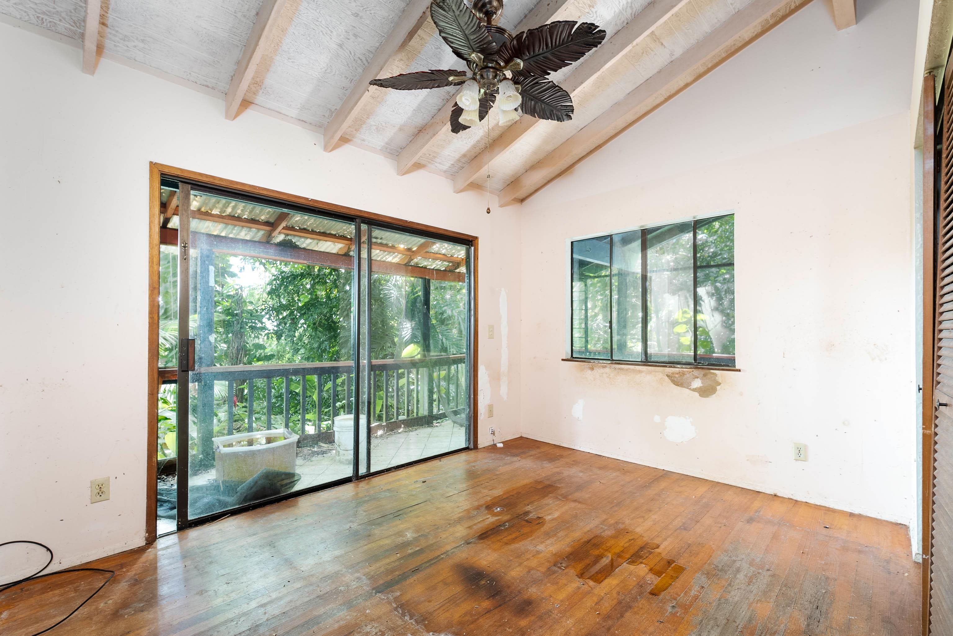 810 Nahiku Road Haiku, HI 96708 - Photo 43 of 50 an empty room with wooden floor and windows