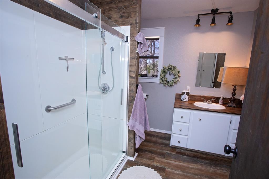 1250 Canyon Road Graham, TX 76450 - Photo 10 of 40 a bathroom with a granite countertop shower a sink and a mirror