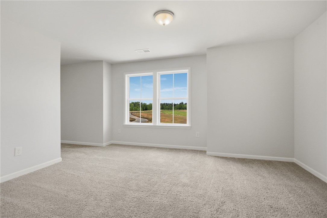 557 Hydrangea Street, Unit LOT 46 Seneca, SC 29678 - Photo 24 of 37 A well-lit, neutral-toned room features new carpeting and a pastoral view.
