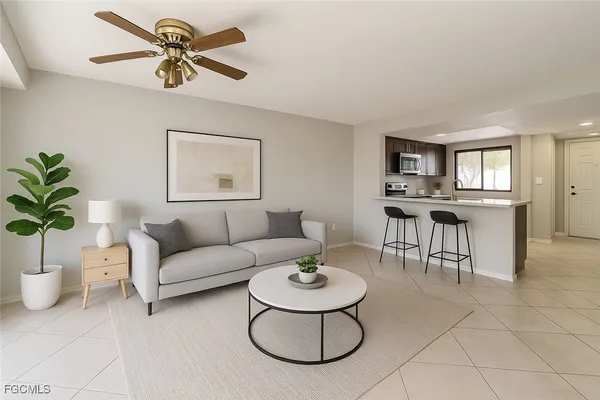 a living room with furniture a chandelier and a dining table