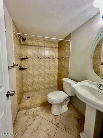 a bathroom with a sink toilet a mirror and shower