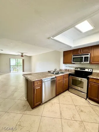 a kitchen with stainless steel appliances granite countertop a stove a sink and a microwave