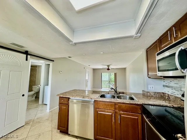 a kitchen with stainless steel appliances granite countertop a sink and a stove