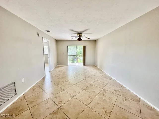 a view of a livingroom with a chandelier fan and window
