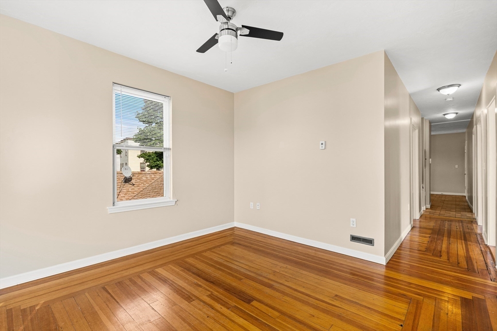 18 St Clair Street, Unit 3 Lynn, MA 01902 - Photo 13 of 36 a view of an empty room with wooden floor and a window