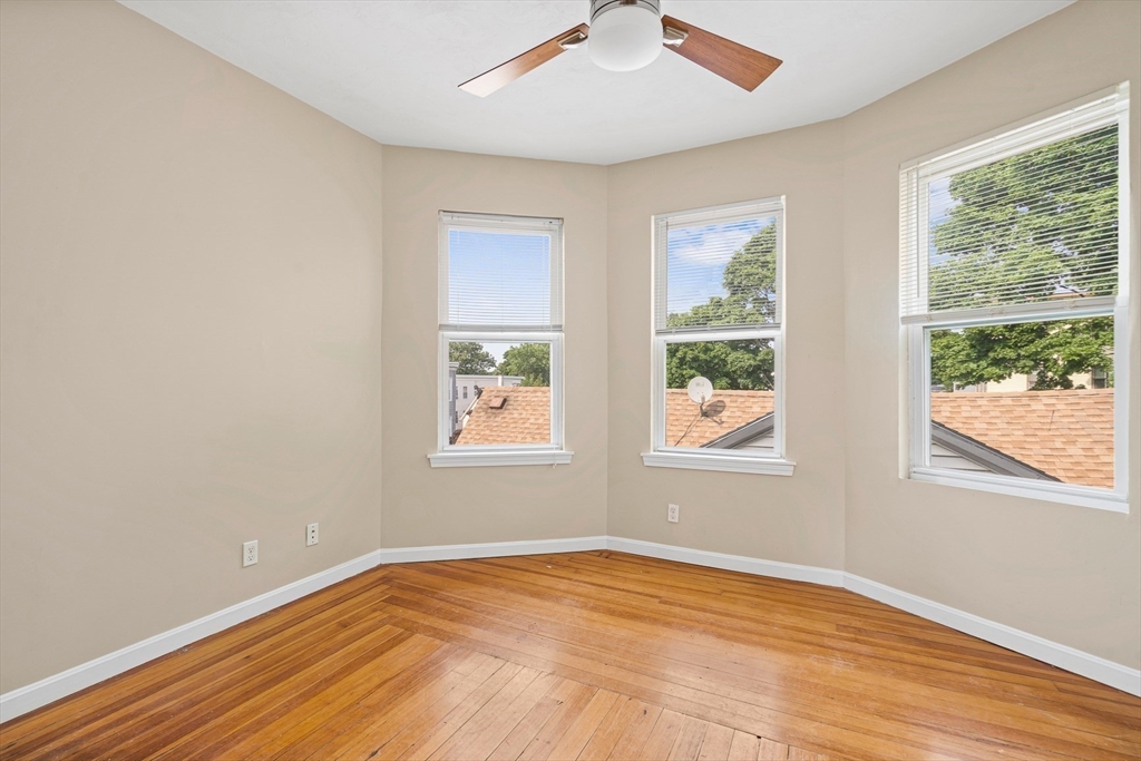 18 St Clair Street, Unit 3 Lynn, MA 01902 - Photo 14 of 36 a view of an empty room with wooden floor and a window