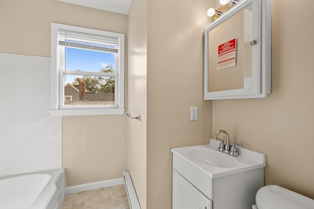 18 St Clair Street, Unit 3 Lynn, MA 01902 - Photo 21 of 36 a bathroom with a toilet sink and mirror