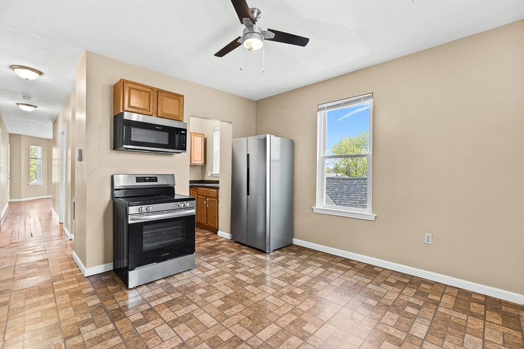 18 St Clair Street, Unit 3 Lynn, MA 01902 - Photo 7 of 36 a view of kitchen with stainless steel appliances granite countertop a stove top oven a refrigerator cabinets kitchen island and a window