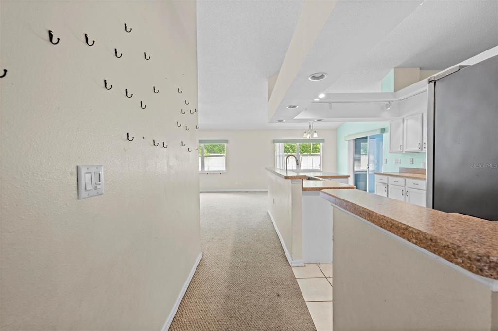 7492 Aloe Drive Spring Hill, FL 34607 - Photo 12 of 57 a view of a kitchen with kitchen island a sink wooden floor and a refrigerator