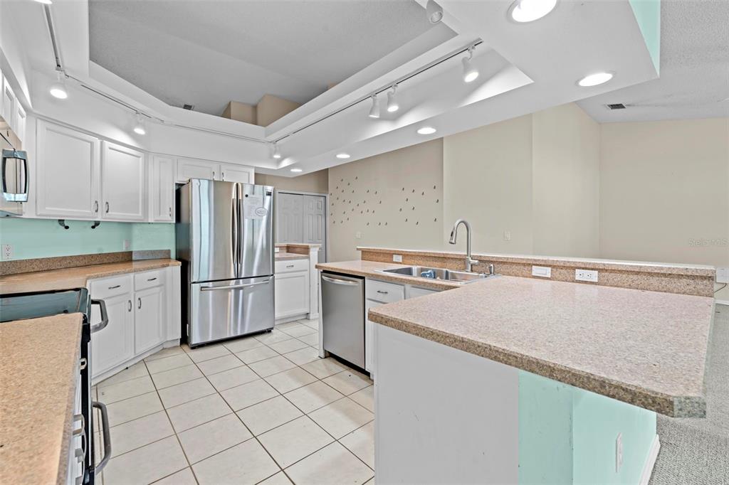 7492 Aloe Drive Spring Hill, FL 34607 - Photo 15 of 57 a kitchen with stainless steel appliances a refrigerator sink and cabinets