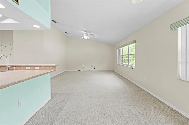 a view of a kitchen with kitchen island wooden floor and stainless steel appliances