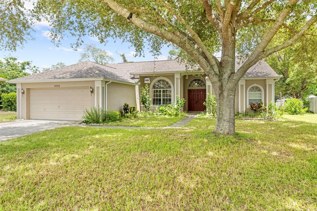 7492 Aloe Drive Spring Hill, FL 34607 - Photo 2 of 57 front view of a house with a yard