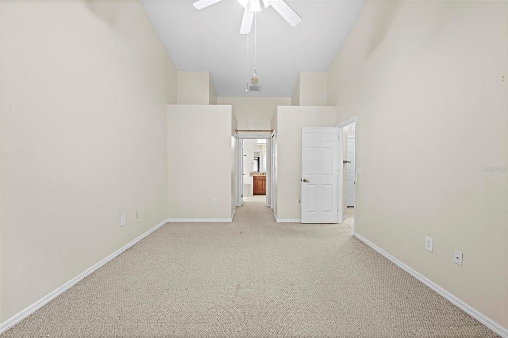 7492 Aloe Drive Spring Hill, FL 34607 - Photo 30 of 57 an empty room with an entryway and chandelier fan