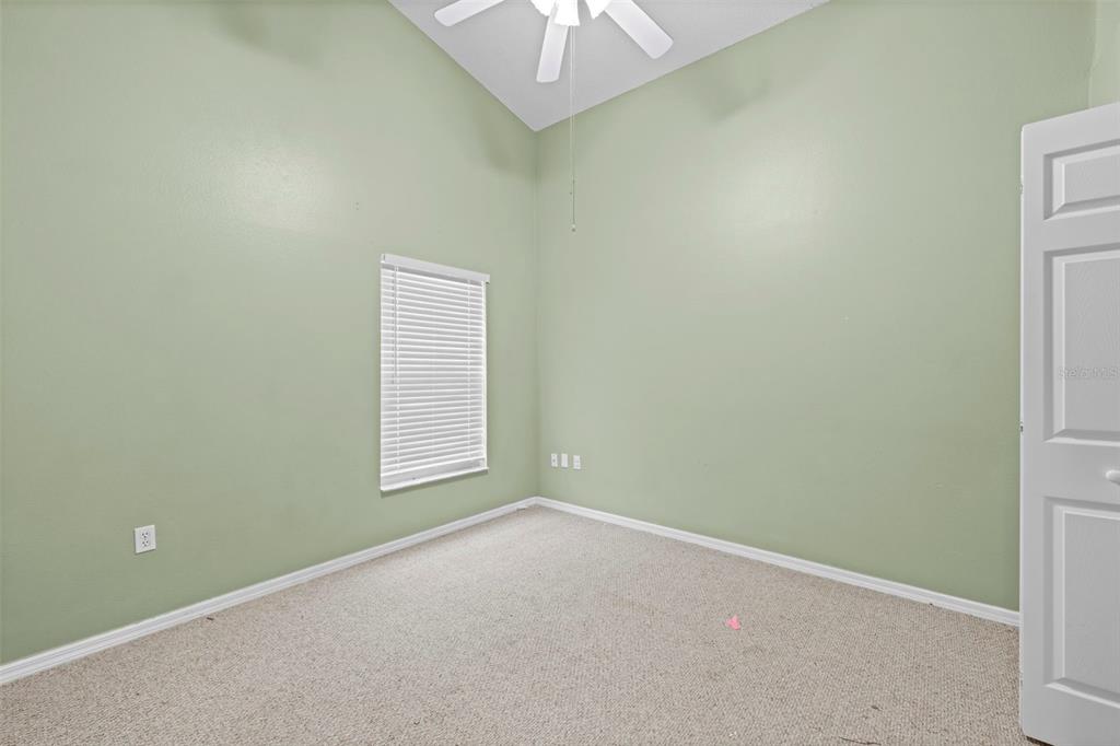 7492 Aloe Drive Spring Hill, FL 34607 - Photo 42 of 57 an empty room with a window and a chandelier fan