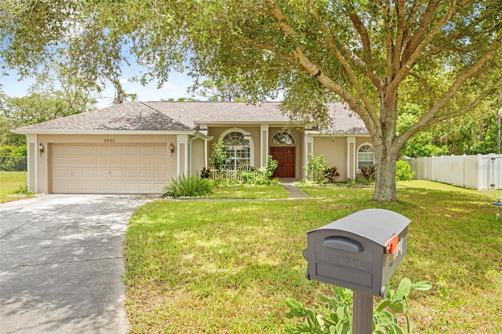 7492 Aloe Drive Spring Hill, FL 34607 - Photo 7 of 57 front view of a house with a yard