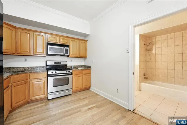 a kitchen with stainless steel appliances a stove a sink and a microwave