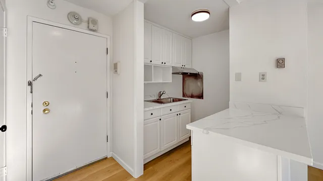 a bathroom with a granite countertop sink and washing machine