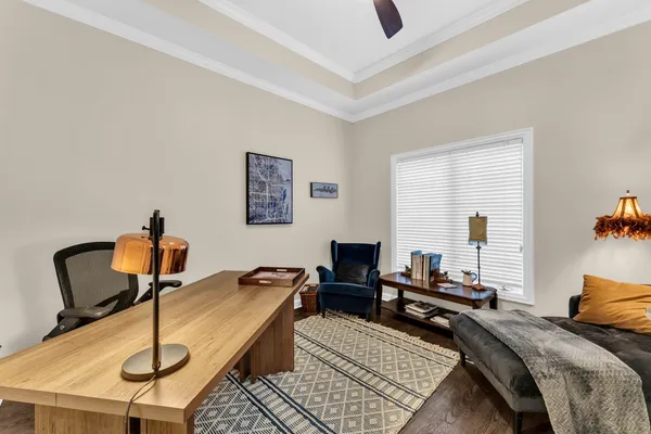 a living room with furniture kitchen view and a wooden floor