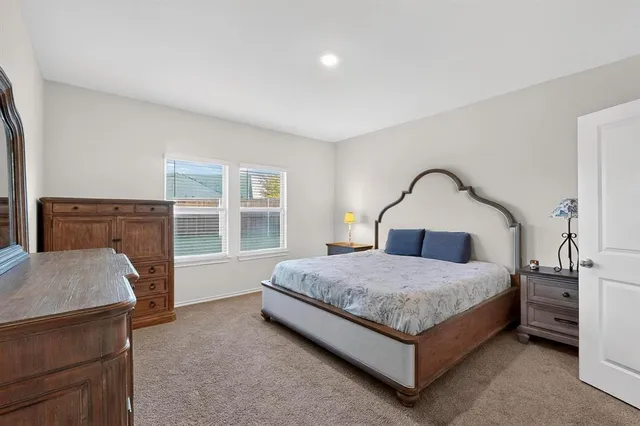 a spacious bedroom with a bed and a dresser