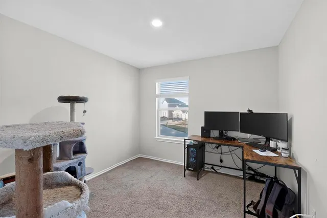 a view of a workspace with furniture and a window