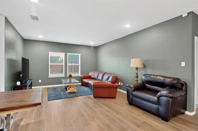a living room with furniture a flat screen tv and a large window