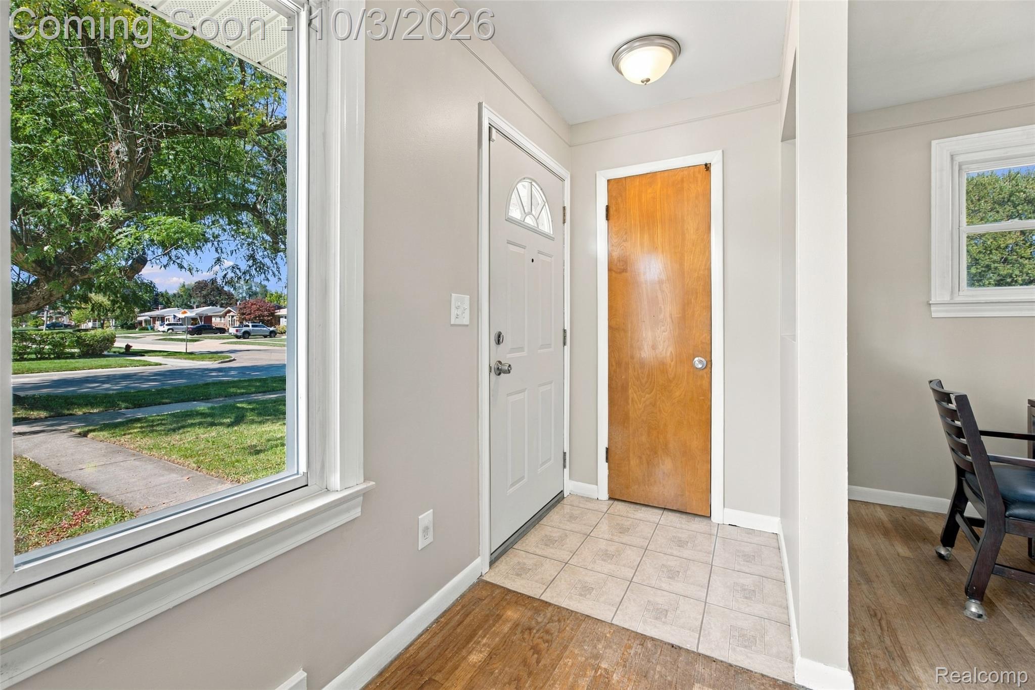 556 Henry Ruff Road Garden City, MI 48135 - Photo 27 of 49 Entryway featuring a white paneled door with decorative glass, tiled flooring, an overhead flush-mount light fixture, and wood-finish flooring extending into an adjacent room