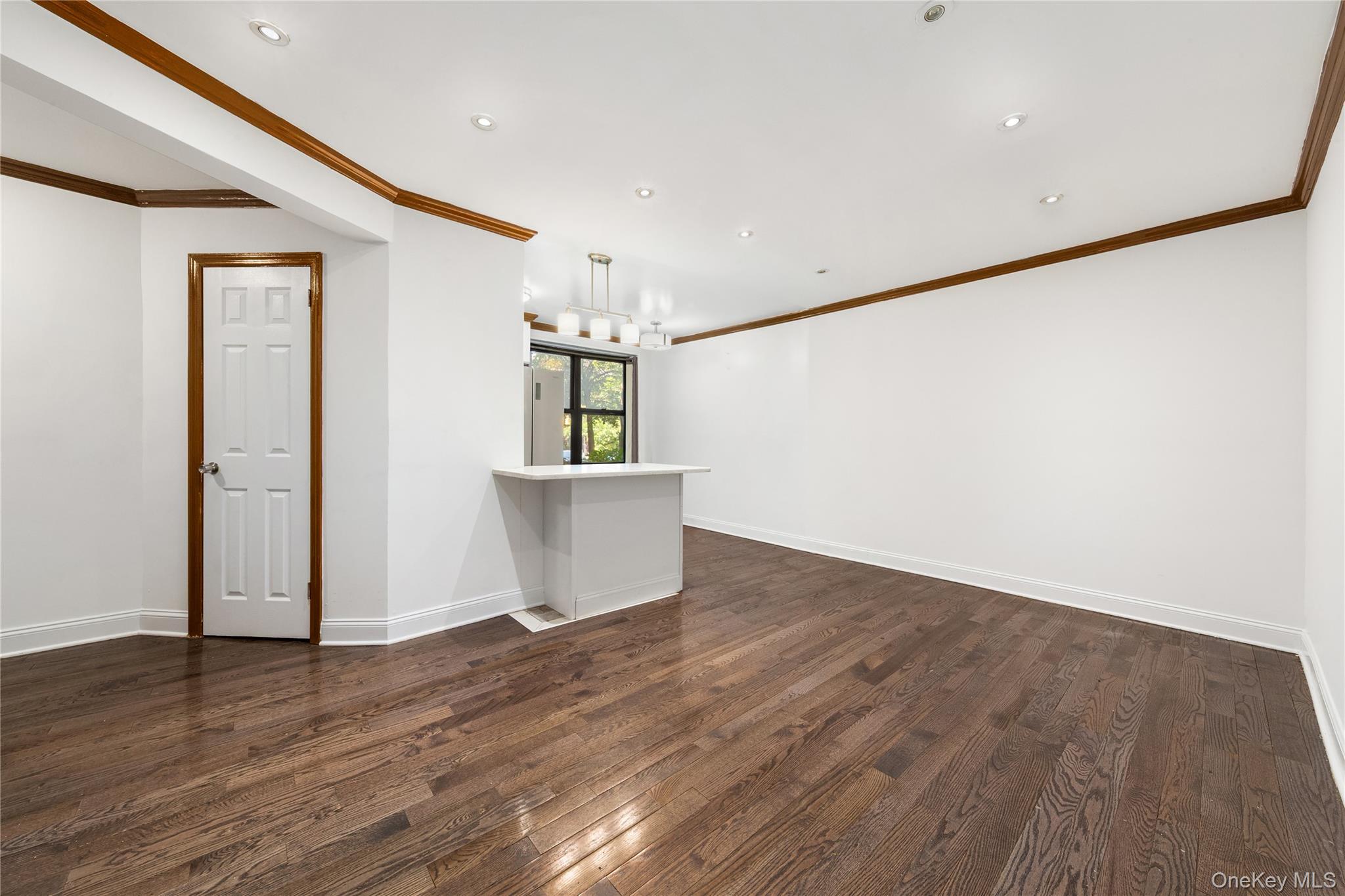 88-10 34th Avenue, Unit 1H Queens, NY 11372 - Photo 2 of 6 a view of a room with wooden floor and a window