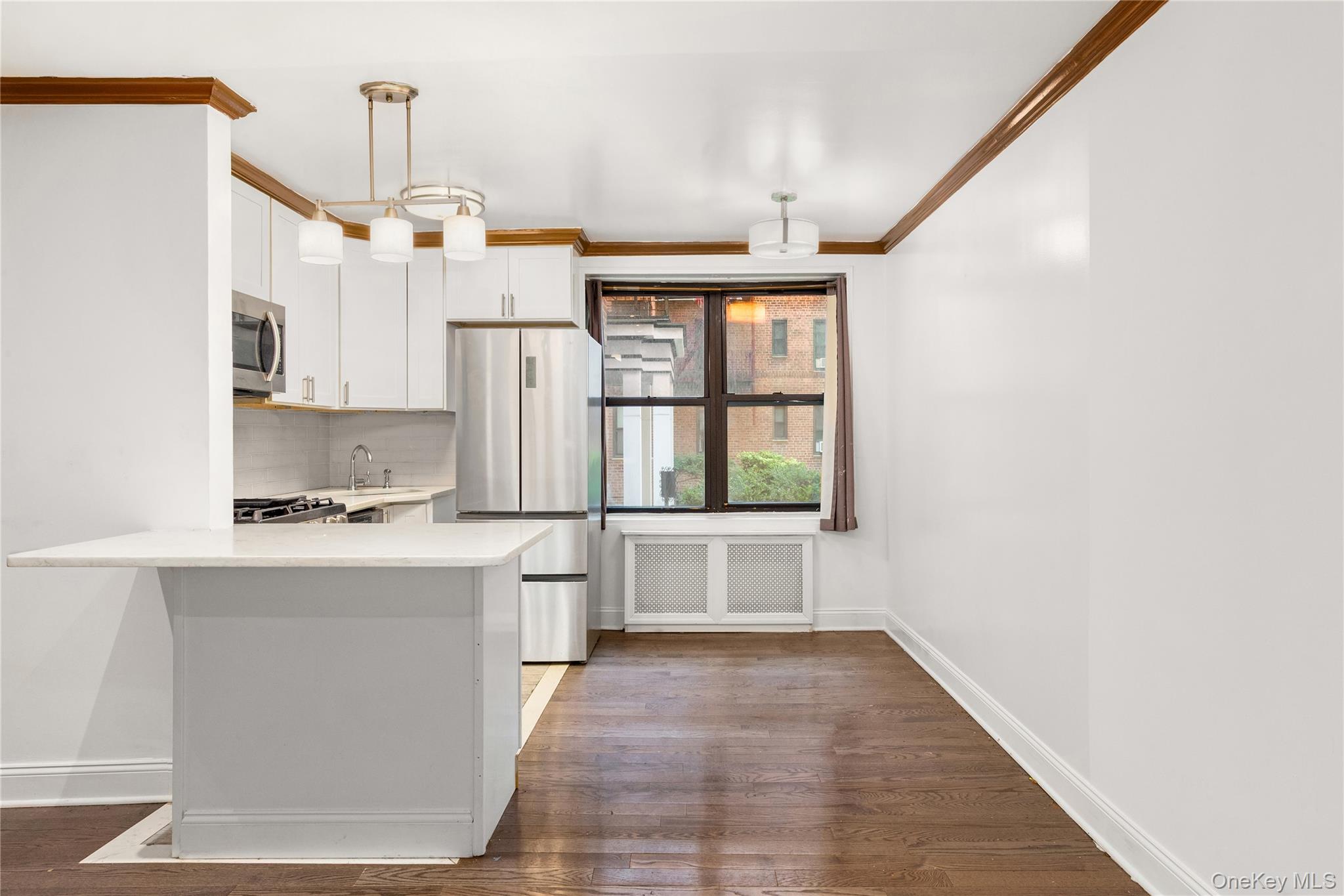 88-10 34th Avenue, Unit 1H Queens, NY 11372 - Photo 4 of 6 a kitchen with stainless steel appliances granite countertop a stove a sink and a refrigerator