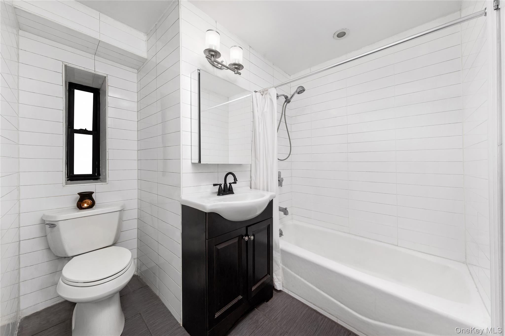 88-10 34th Avenue, Unit 1H Queens, NY 11372 - Photo 6 of 6 a bathroom with a sink a toilet and shower