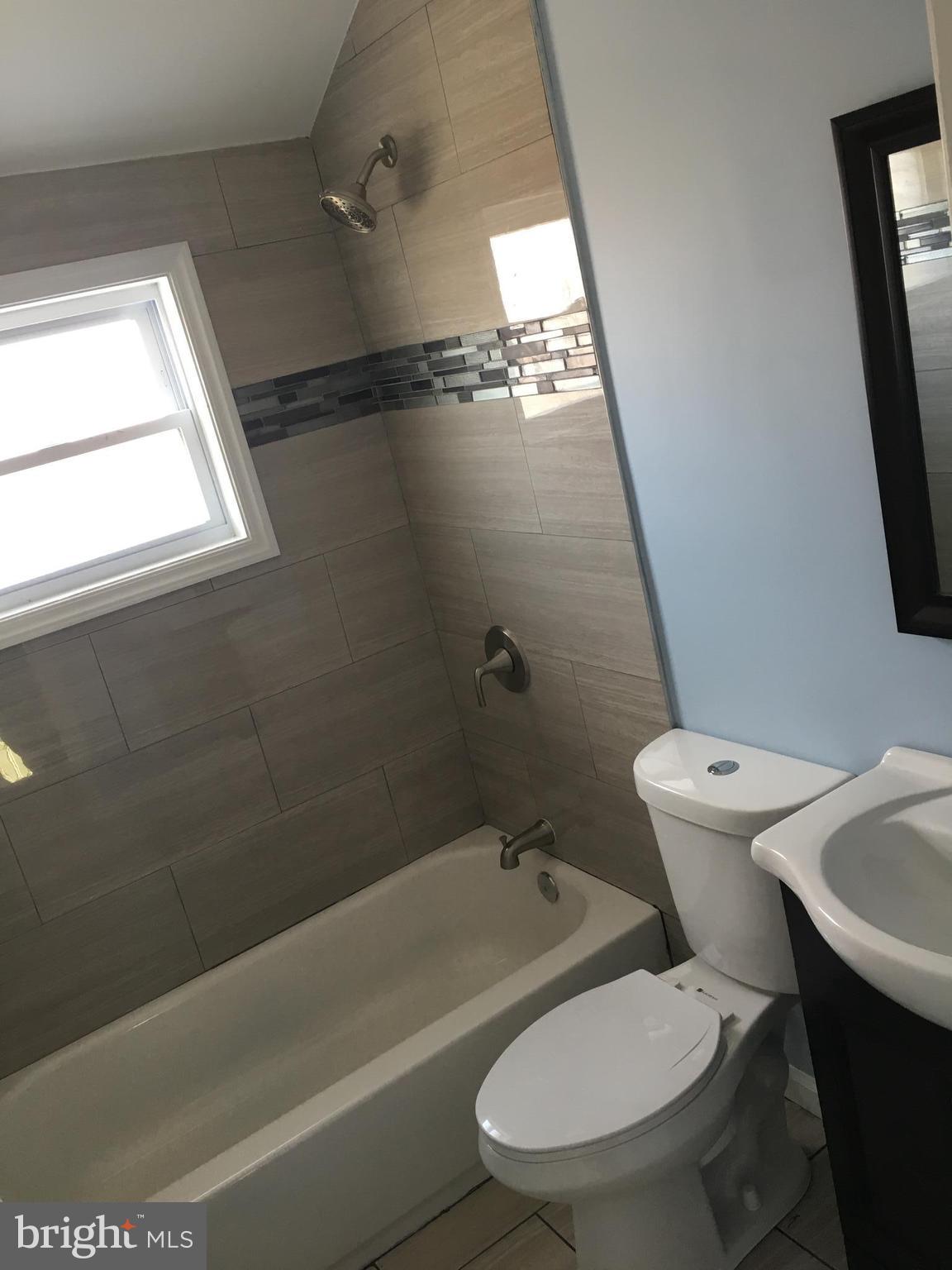 926 Arncliffe Road Baltimore, MD 21221 - Photo 11 of 24 a white toilet sitting next to a bath tub