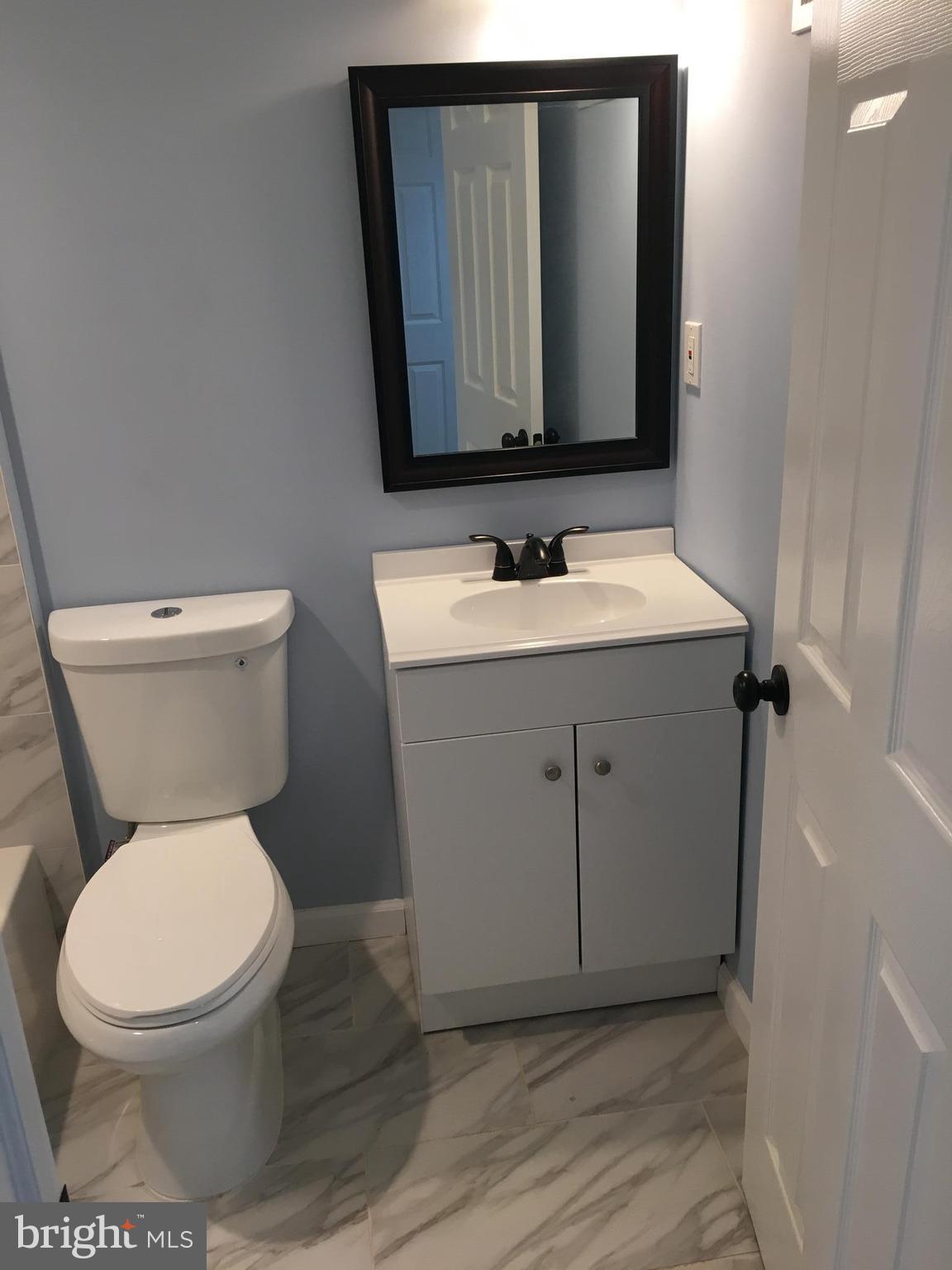926 Arncliffe Road Baltimore, MD 21221 - Photo 20 of 24 a bathroom with a toilet sink and mirror