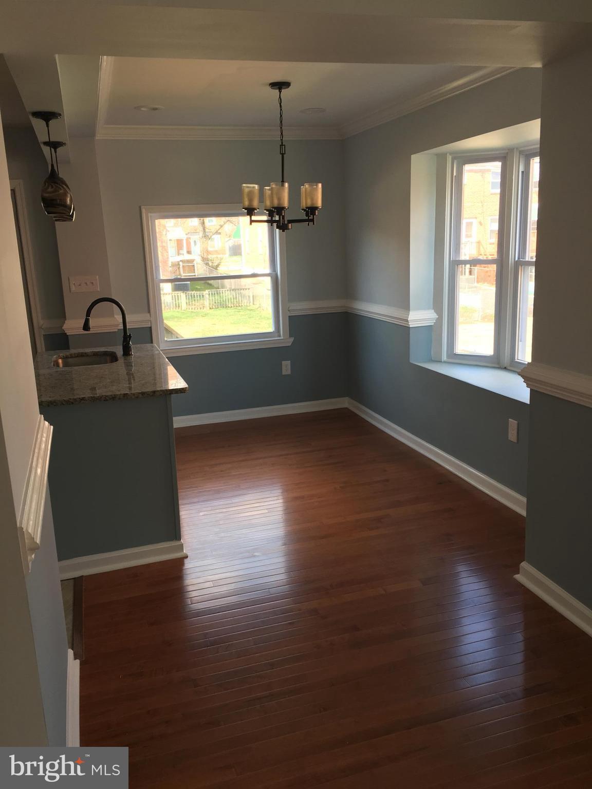 926 Arncliffe Road Baltimore, MD 21221 - Photo 6 of 24 an empty room with wooden floor windows and fireplace
