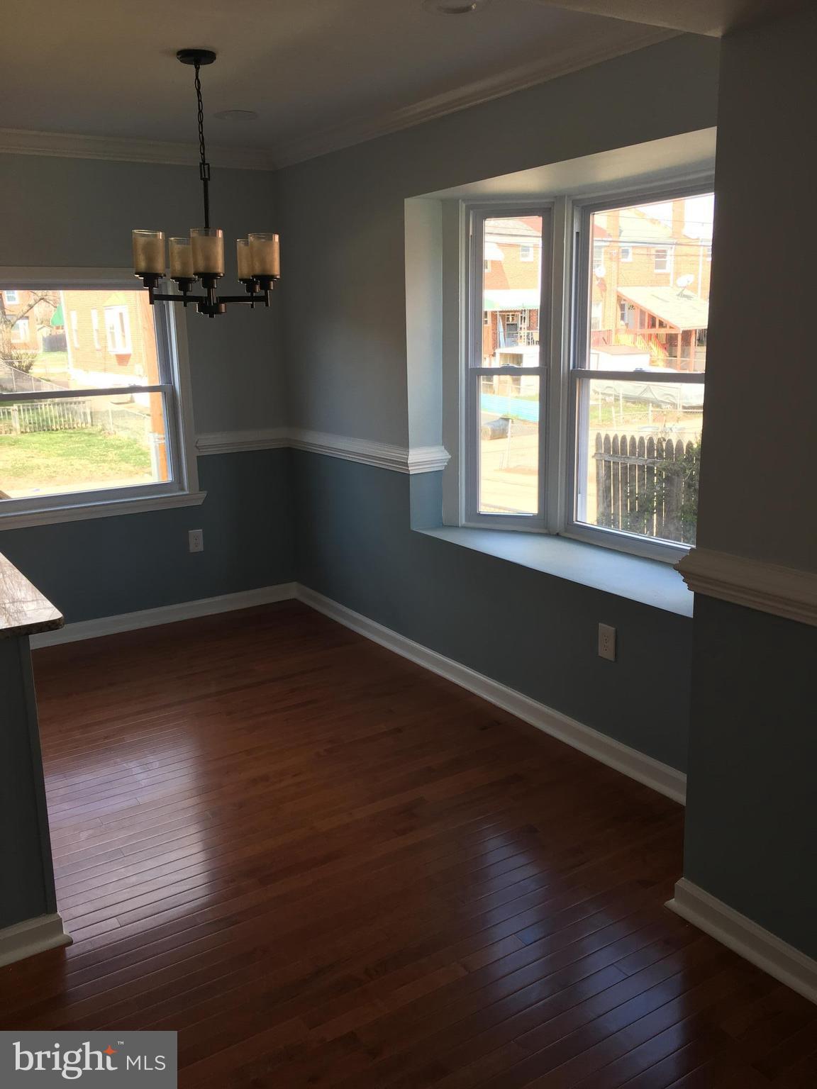 926 Arncliffe Road Baltimore, MD 21221 - Photo 9 of 24 a view of a room with wooden floor chandelier and windows