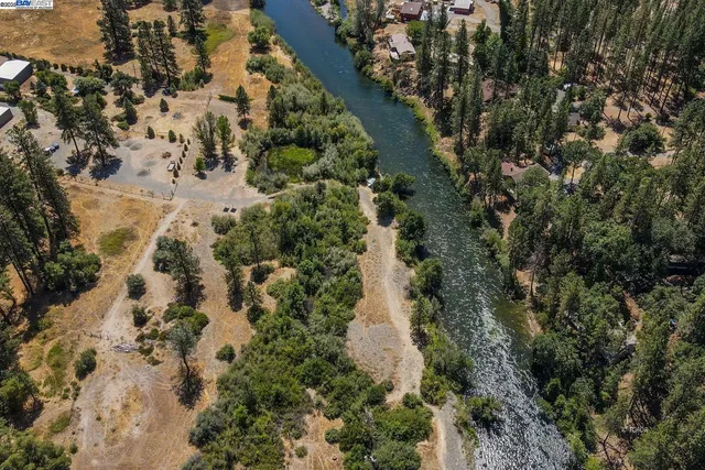 an aerial view of a house with a yard and lake view