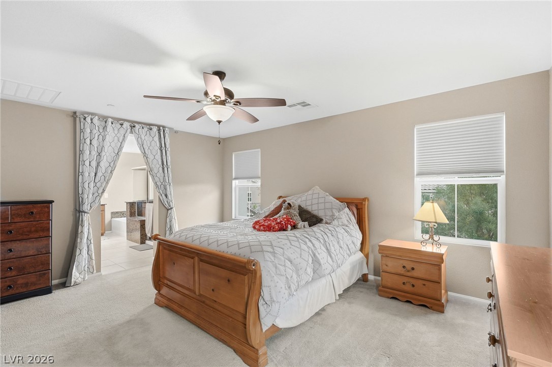 150 Fulgora Street Henderson, NV 89074 - Photo 44 of 92 Bedroom with light carpet, ceiling fan, and connected bathroom