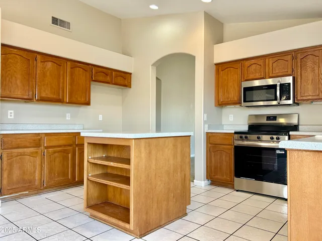 a kitchen with stainless steel appliances granite countertop a refrigerator and a stove top oven