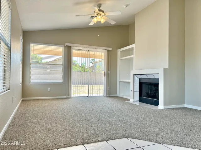 an empty room with windows and fireplace