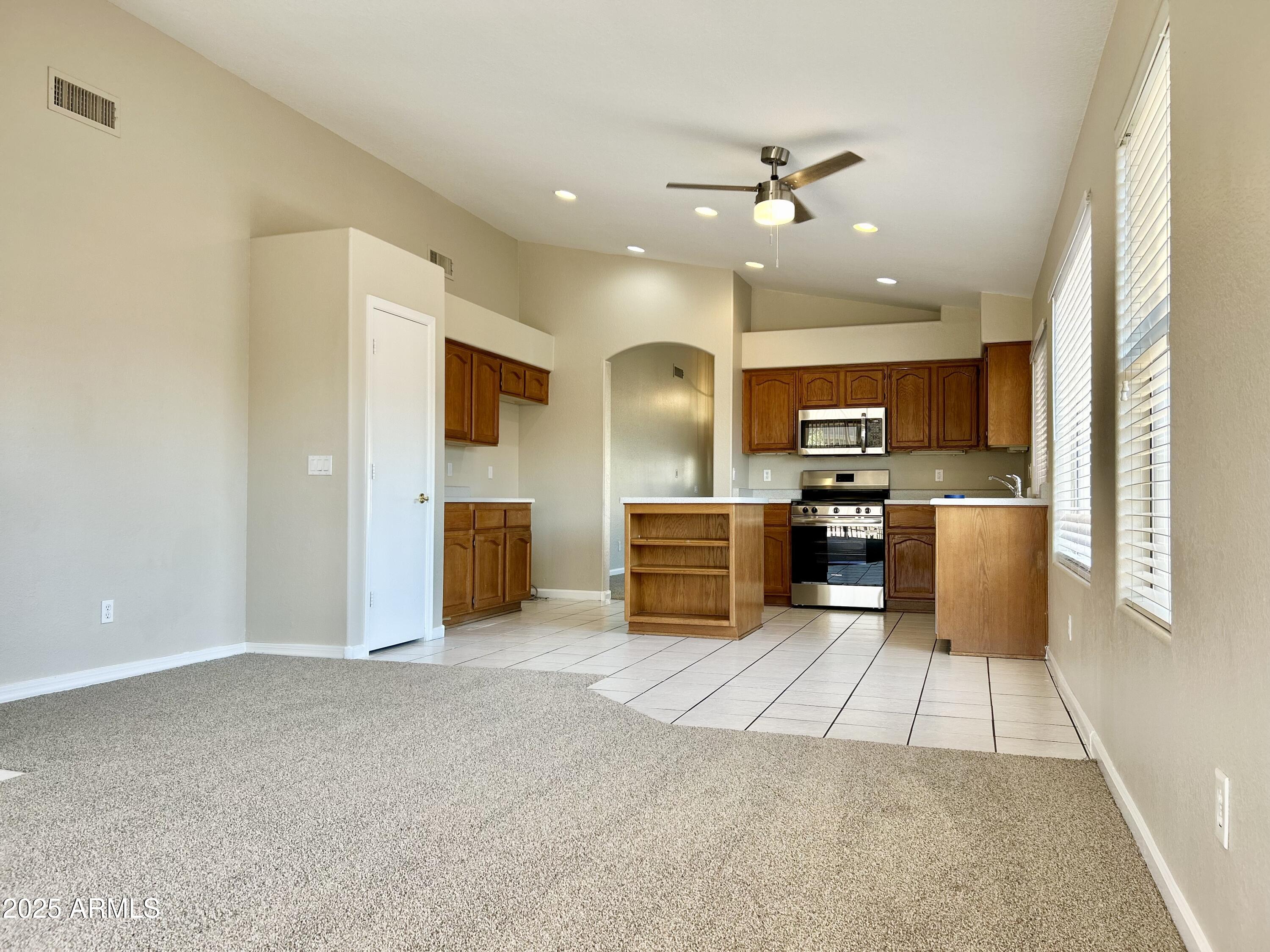 437 West San Angelo Gilbert, AZ 85233 - Photo 9 of 21 a large kitchen with stainless steel appliances kitchen island granite countertop a refrigerator oven a sink and dishwasher with white cabinets