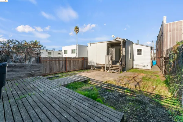 a view of a backyard with couches plants and wooden fence