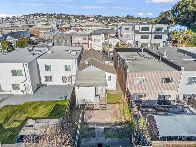 an aerial view of residential houses with outdoor space and seating area