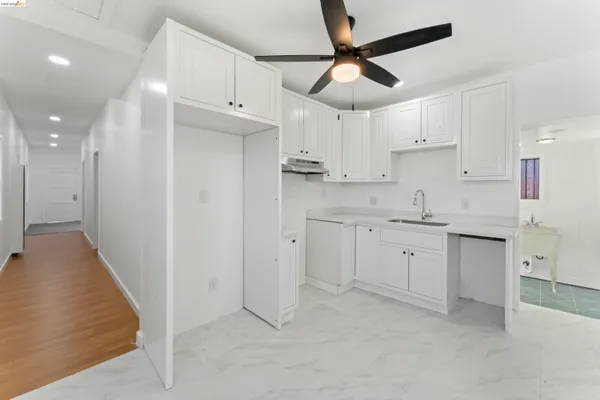 a kitchen with cabinets appliances and a ceiling fan
