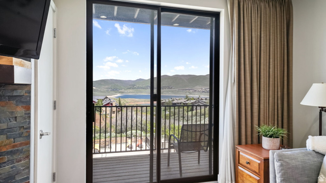1364 Still Water Drive, Unit R2012 Heber City, UT 84032 - Photo 13 of 30 Sliding glass door leading to a balcony with black metal railings, overlooking a lake and distant mountains