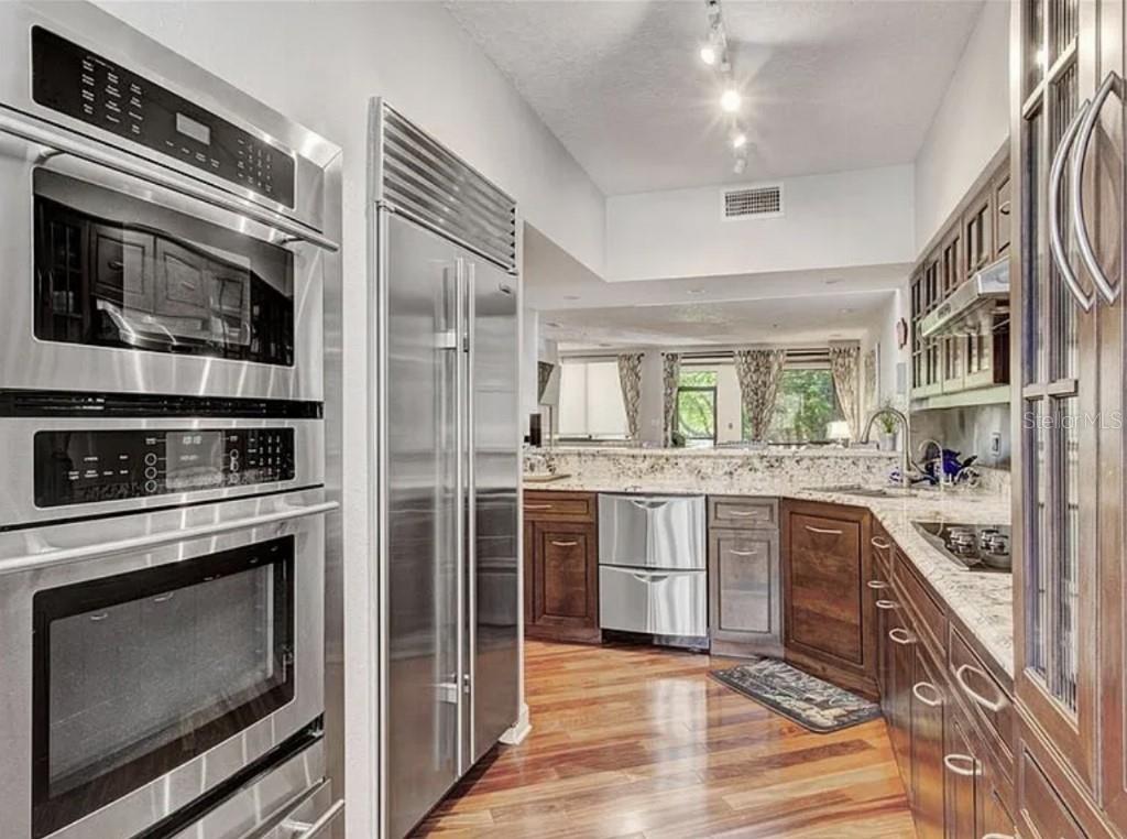 1926 Harbourside Drive, Unit 1302 Longboat Key, FL 34228 - Photo 13 of 31 a kitchen with stainless steel appliances granite countertop a stove microwave and refrigerator