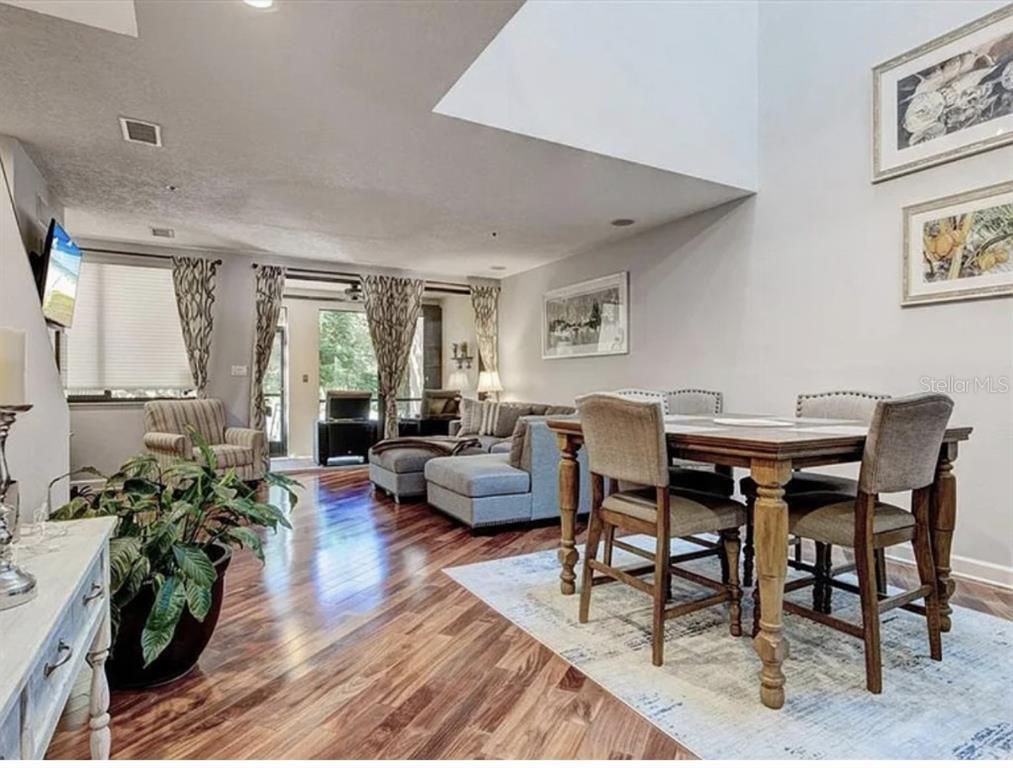 1926 Harbourside Drive, Unit 1302 Longboat Key, FL 34228 - Photo 2 of 31 a living room with furniture a dining table and a potted plant
