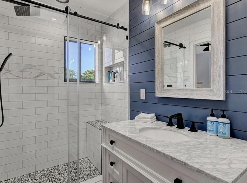 1926 Harbourside Drive, Unit 1302 Longboat Key, FL 34228 - Photo 21 of 31 a bathroom with a granite countertop sink a mirror and shower
