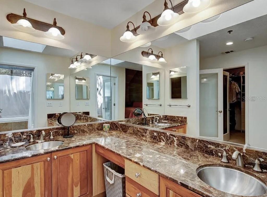 1926 Harbourside Drive, Unit 1302 Longboat Key, FL 34228 - Photo 22 of 31 a bathroom with a granite countertop double vanity sink and a mirror