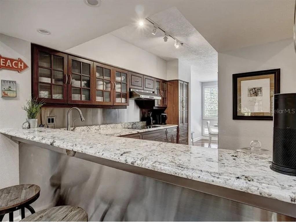 1926 Harbourside Drive, Unit 1302 Longboat Key, FL 34228 - Photo 7 of 31 a kitchen with stainless steel appliances granite countertop a sink refrigerator and stove