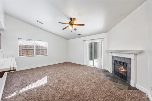 a view of empty room with fireplace and fan